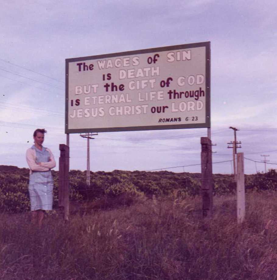Lois Farrow by the sign on her father&rsquo;s Pāpāmoa section (1960s)