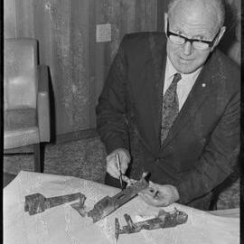 Tauranga Electric Power Board chief engineer displaying badly corroded galvanised metal brackets from Pāpāmoa buildings.