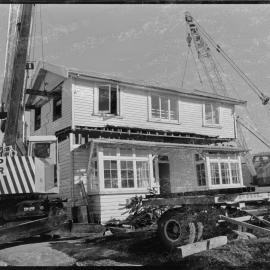 Cutting a house in half to move it from 1st Avenue to near the old Pāpāmoa garage on State Highway 2 - starting to lift.