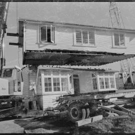 Cutting a house in half to move it from 1st Avenue to near the old Pāpāmoa garage on State Highway 2 - daylight between the halves.