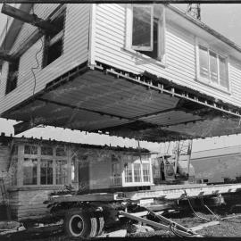 Cutting a house in half to move it from 1st Avenue to near the old Pāpāmoa garage on State Highway 2 - moving towards the trailer.