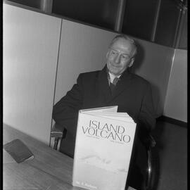 Mr W. T. Parham with his newly-published book on Whakaari / White Island, "Island volcano".