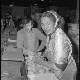 Mr R. E. Harding watching Mrs L. Tawa pack grapefruit at the Citrus Marketing Authority plant.