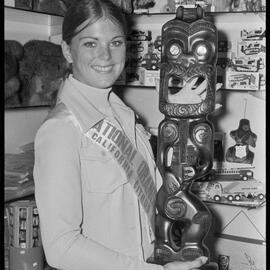 Caroline Fogg, the 1973 California Citrus Queen, admires a carving at Mangere Airport.