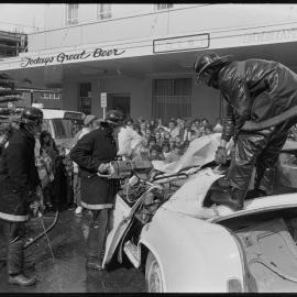 Tauranga Fire Brigade members demonstrate freeing a trapped 'victim' from a wrecked car.
