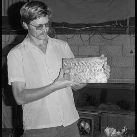 Man hold metal plaque