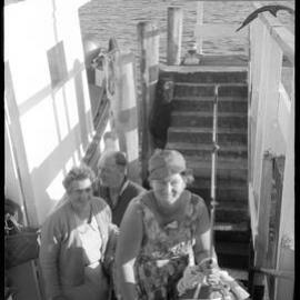Mr C. R. Faulkner helps Mrs Pemberton to disembark. Tga Federation of Country W. Institutes visit to Mayor Is. 