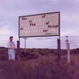 Lois Farrow by the sign on her father’s Papamoa section (1960s)
