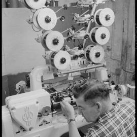 TISCO. A technician watching a dial while he winds on the coil for T.V. receiver