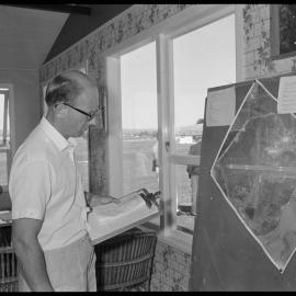 Tauranga Aero Club assistant flying instructor Allan Fletcher (right) explains aerial photograph of Tauranga Airport to pilots during briefings before Royal New Zealand Aero Club's pageant  