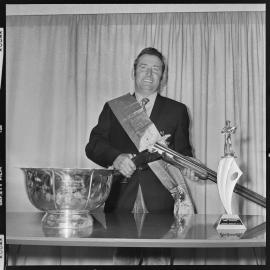Trap shooting trophy winner poses with gun