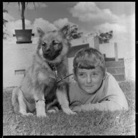Young boy on the grass with his puppy