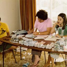 Woman and Two Children at a Table with Cash