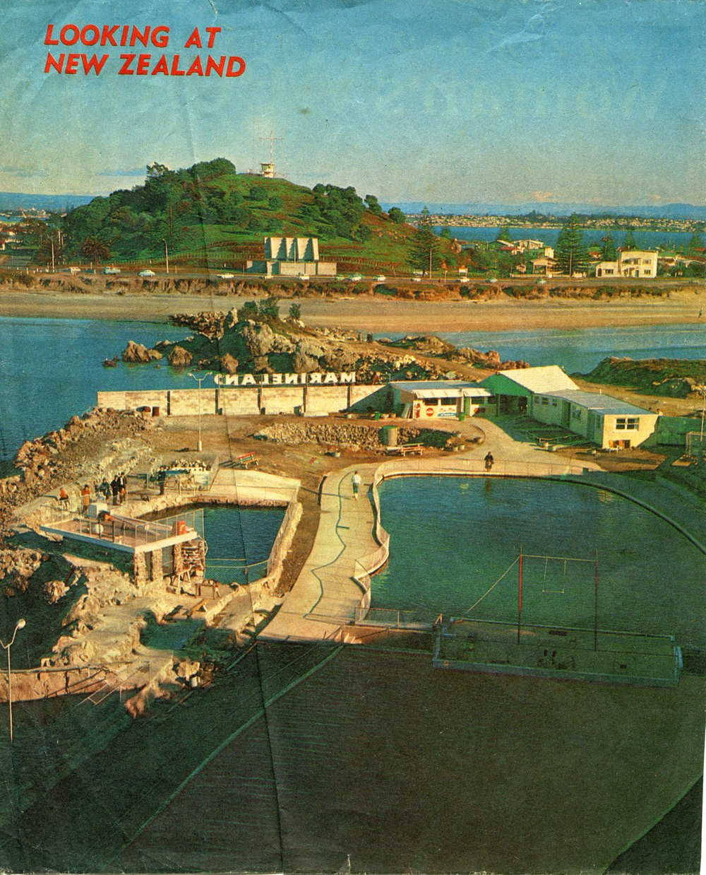View from inside Marineland looking towards Hopukiore (Mount Drury), published inside the front cover of the New Zealand Women's Weekly on 1 November 1976.

Te Ao Mārama - Tauranga City Libraries Photo 11-049