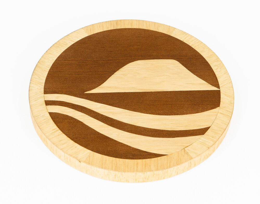Wooden circular marquetry plaque with detail depicting Mauao and the ocean.
Te Ao Mārama - Tauranga City Libraries Ams 418/3/8